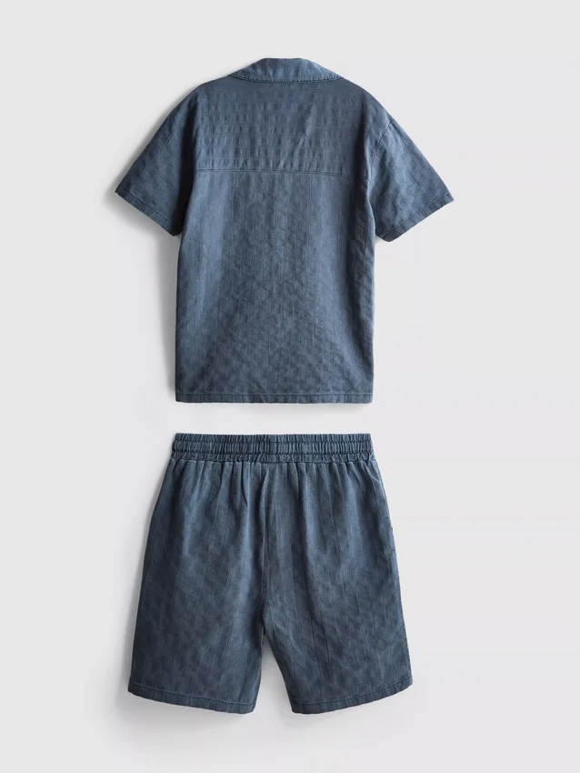 7-15 år | sæt bestående af kortærmet skjorte med knapper og shorts i strukturvævet stof