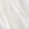 Cami-top i bomuld med broderet peplum-kant