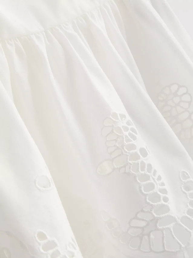 Cami-top i bomuld med broderet peplum-kant