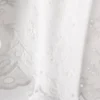 Top med broderi og bindebånd i siden