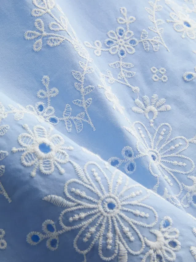 Top med broderi og bindebånd i siden