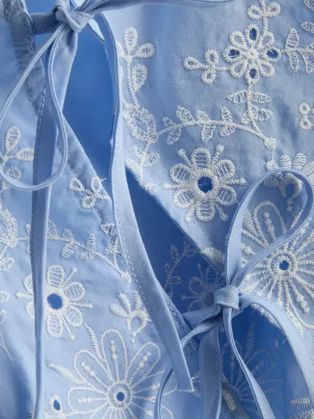 Top med broderi og bindebånd i siden